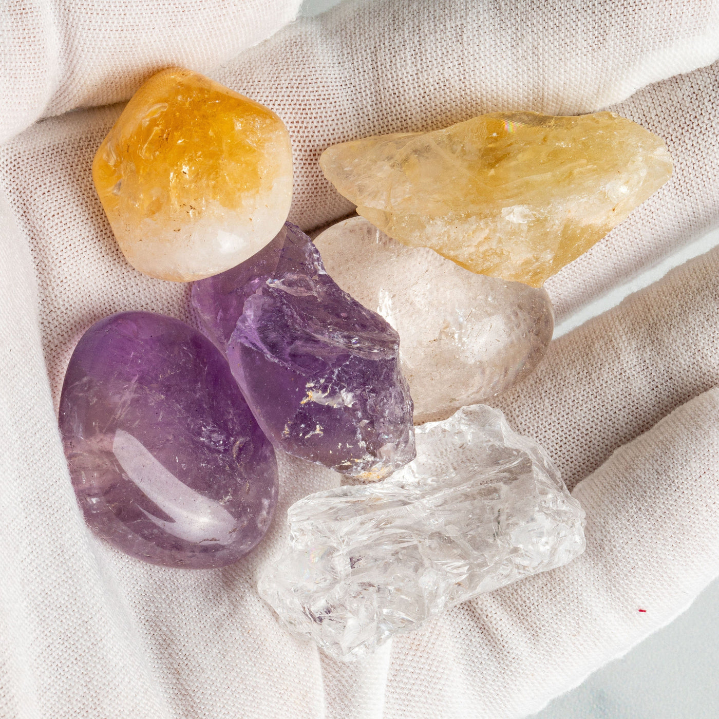 Triple Energy Set of Quartz, Amethyst and Citrine Tumbled and Roughup close in a hand