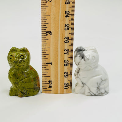 gemstone cats next to a ruler for size reference 