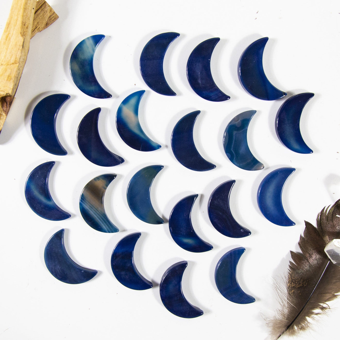 Many blue agate moons on a white surface displaying variation in pattern and color.
