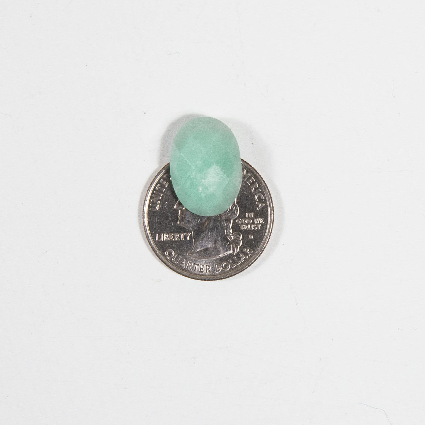 One of the cabochons is being displayed on top of a quarter for size reference. 