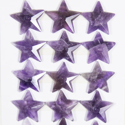 12 amethyst star cabochons on white background