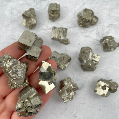 Pyrite Clusters and Cubes - by Weight in hand for size reference 