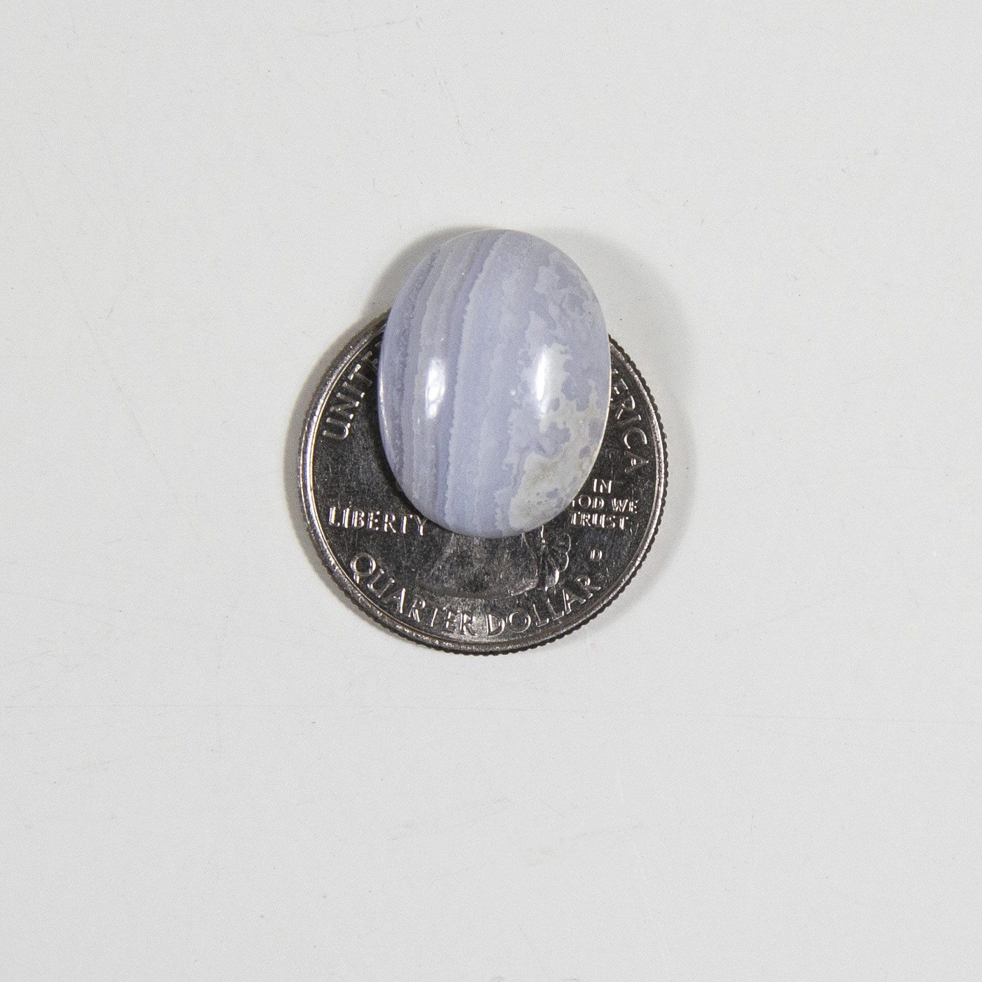 Blue lace cabochon displayed on quarter for another size reference