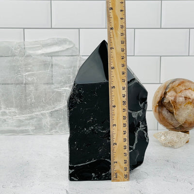 Black Obsidian Semi Polished Point next to a ruler for size reference 