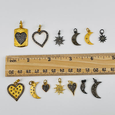 pendants next to a ruler for a size reference 