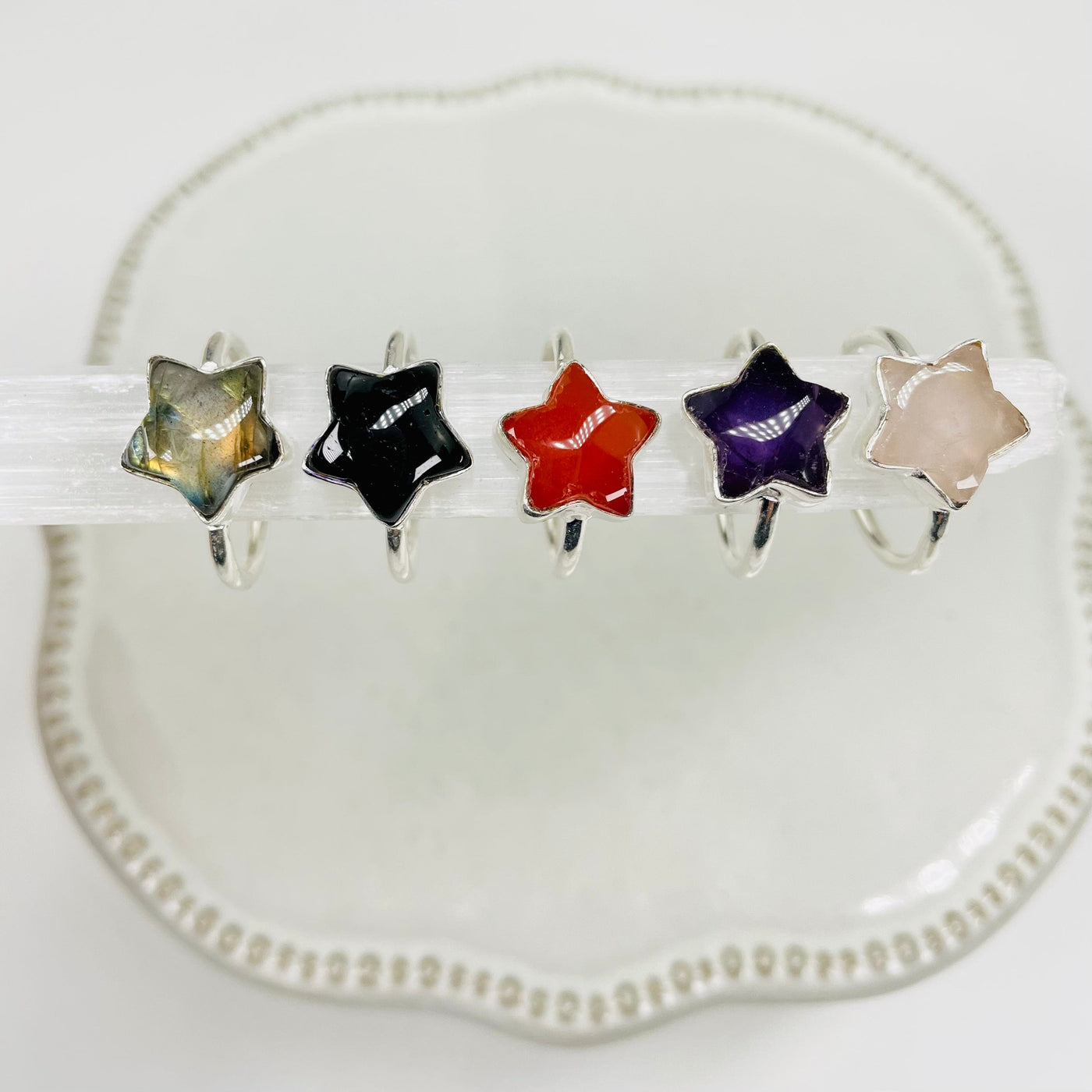 gemstone star rings in silver displayed next to each other to show the differences in the gemstones