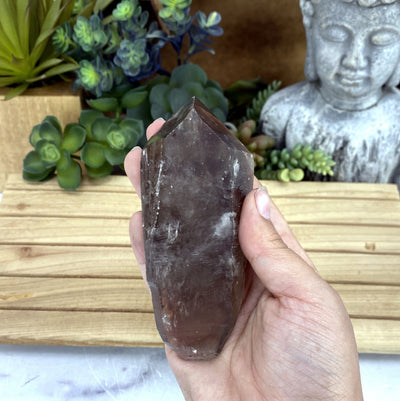 smokey quartz natural point in hand for size reference