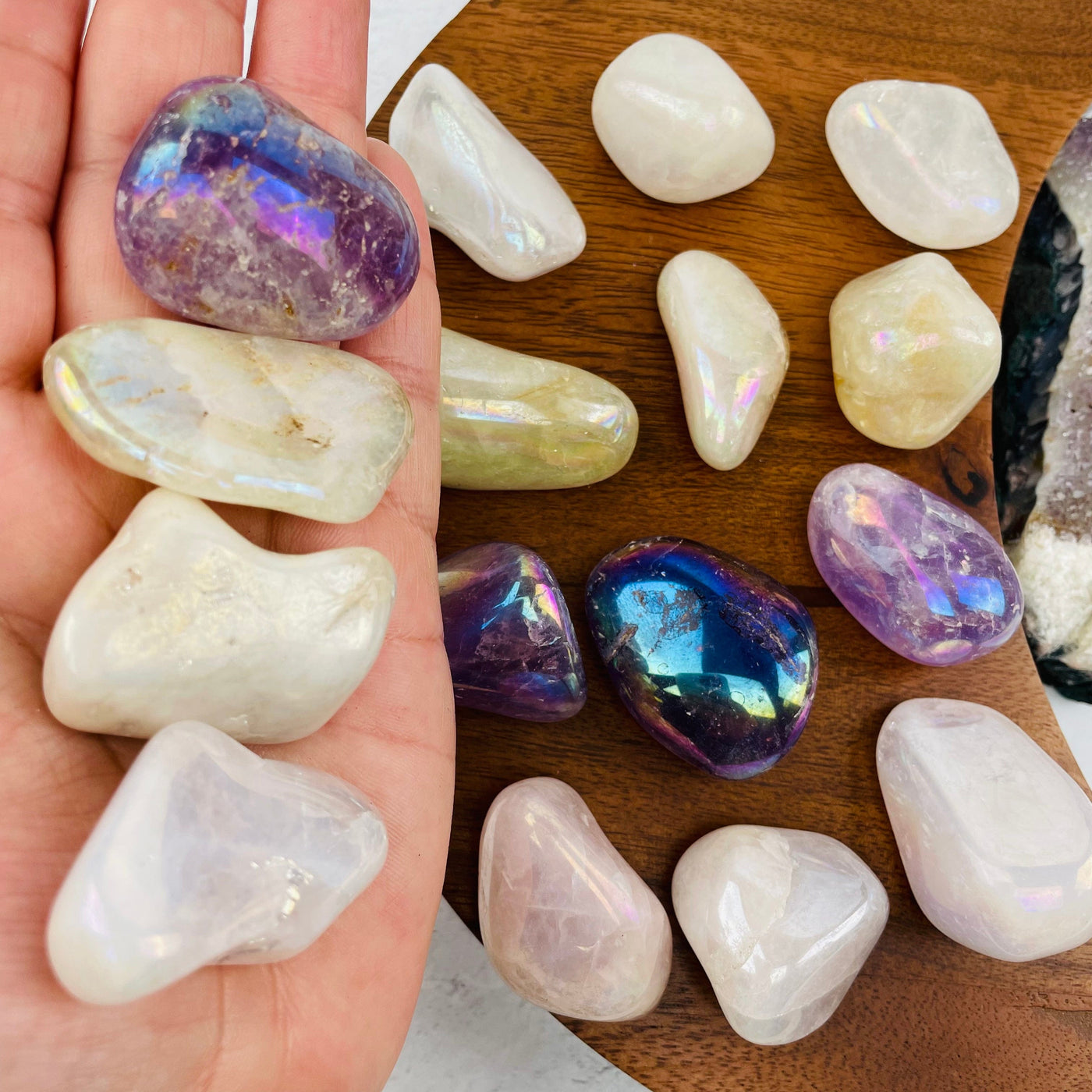Angel Aura Quartz Tumbled Stones in hand for size reference 