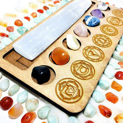 Chakra and Selenite Charging Set--close side shot view of stones on wood with symbols.