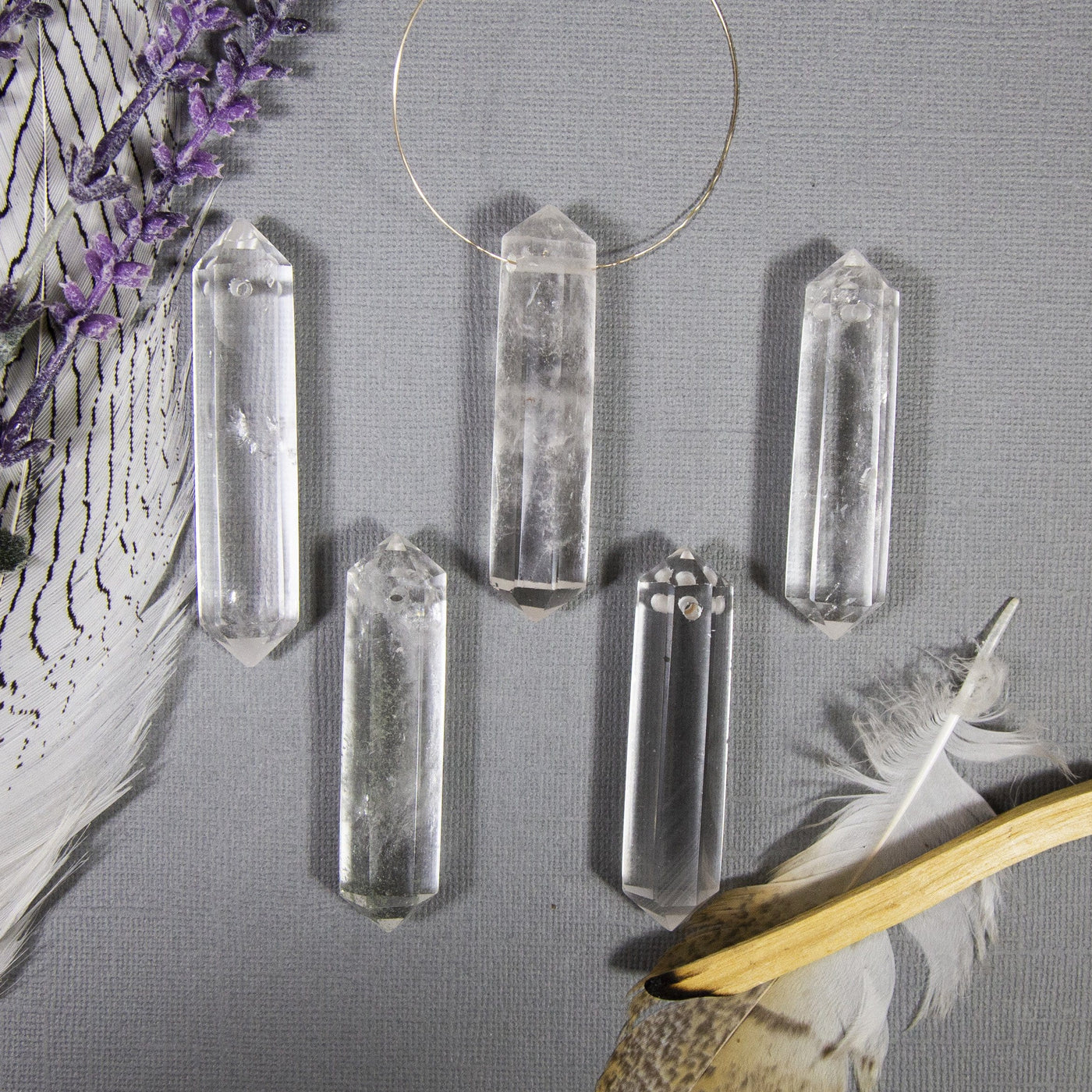 crystal quartz double terminated bead with decorations in the background