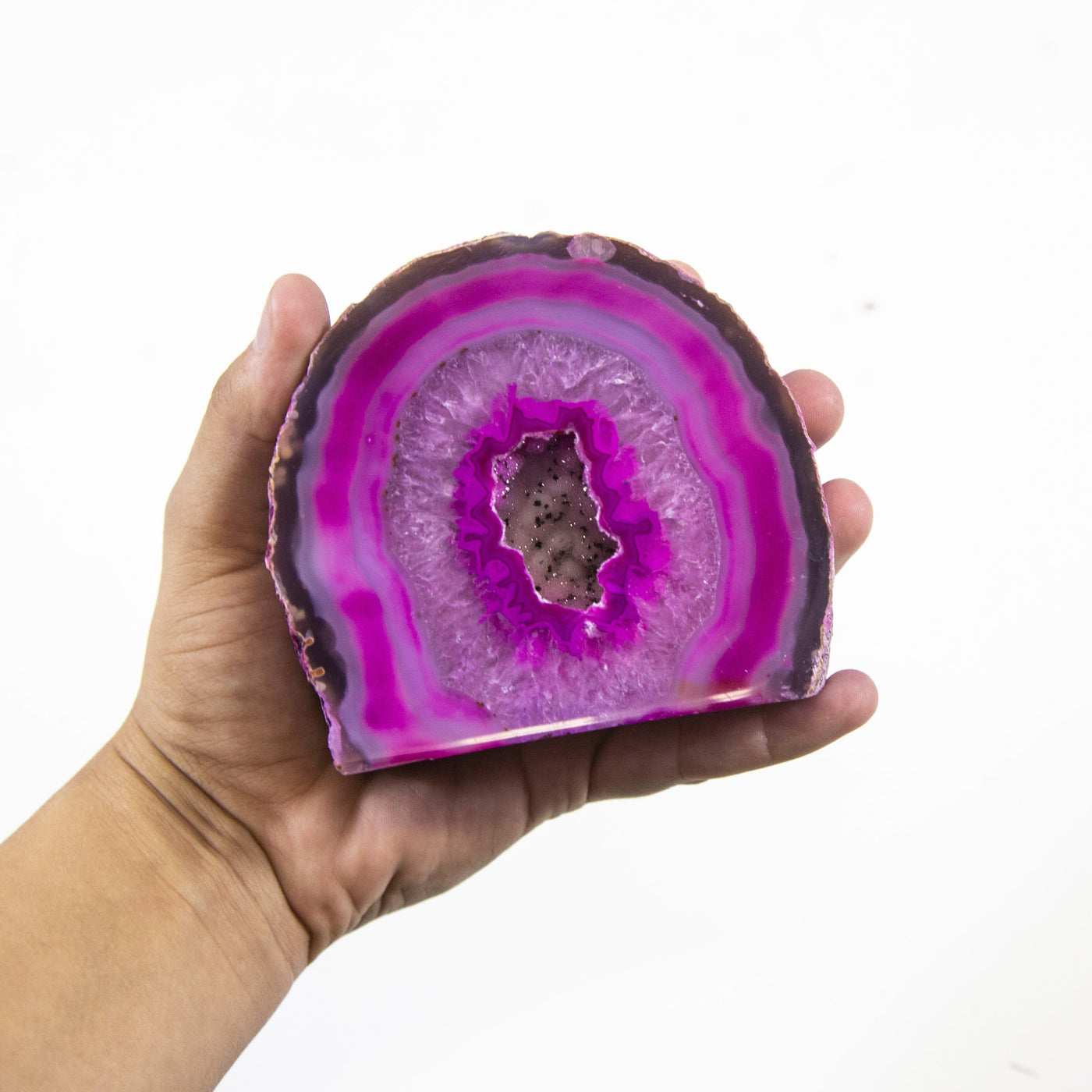 A front facing pink Agate Half Geode Druzy in a hand.