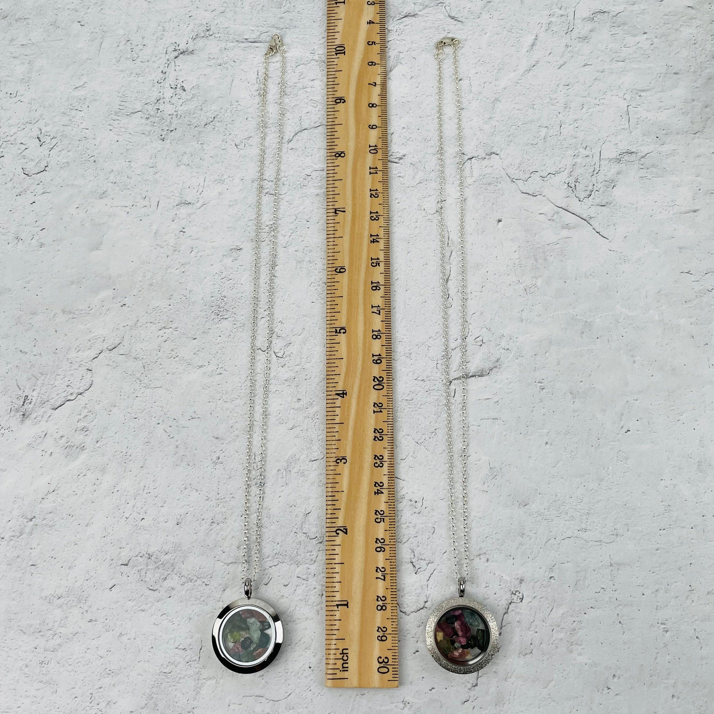 necklace and pendant next to a ruler for size reference. comes on an 18" silver chain 