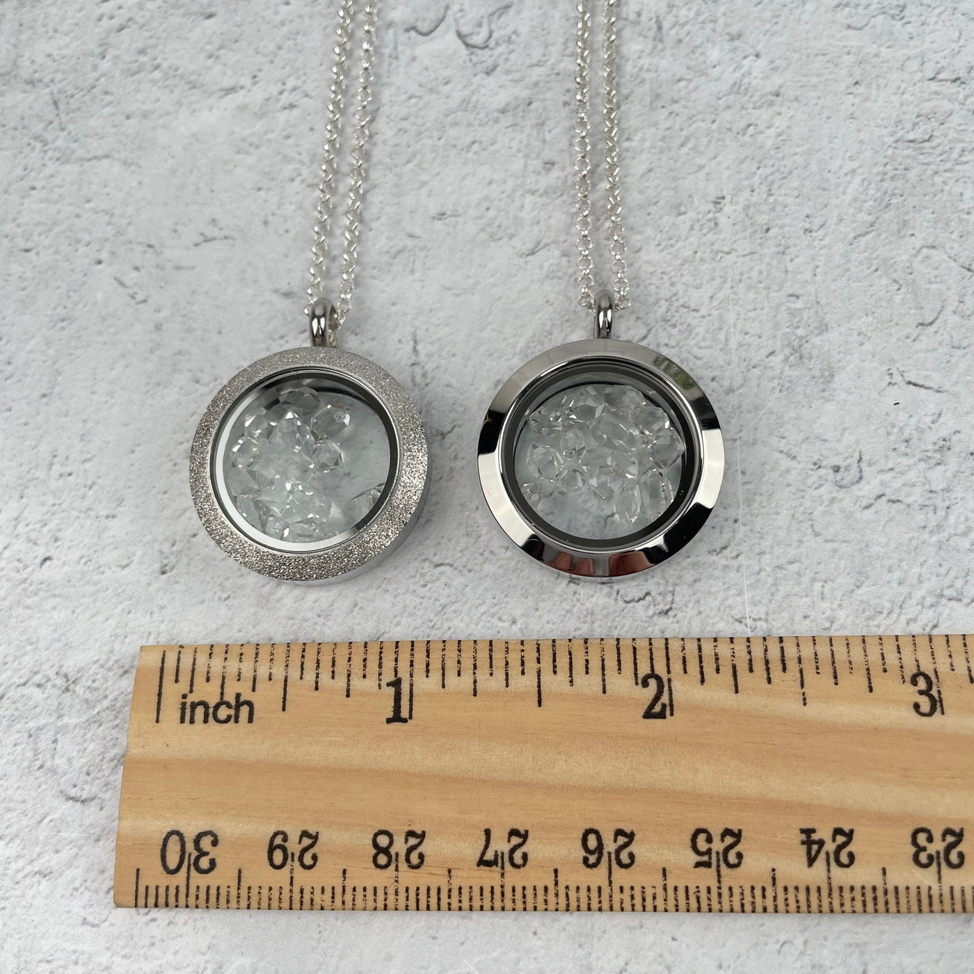 pendants next to a ruler for size reference 