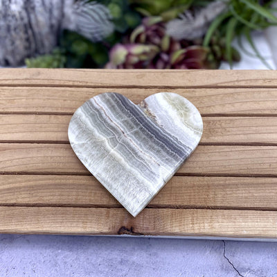 Aragonite Heart on wooden background with decorations