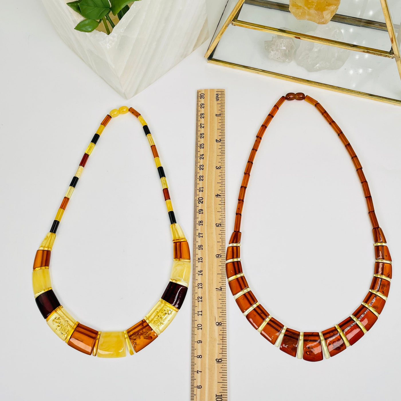 amber necklaces next to a ruler for size reference 