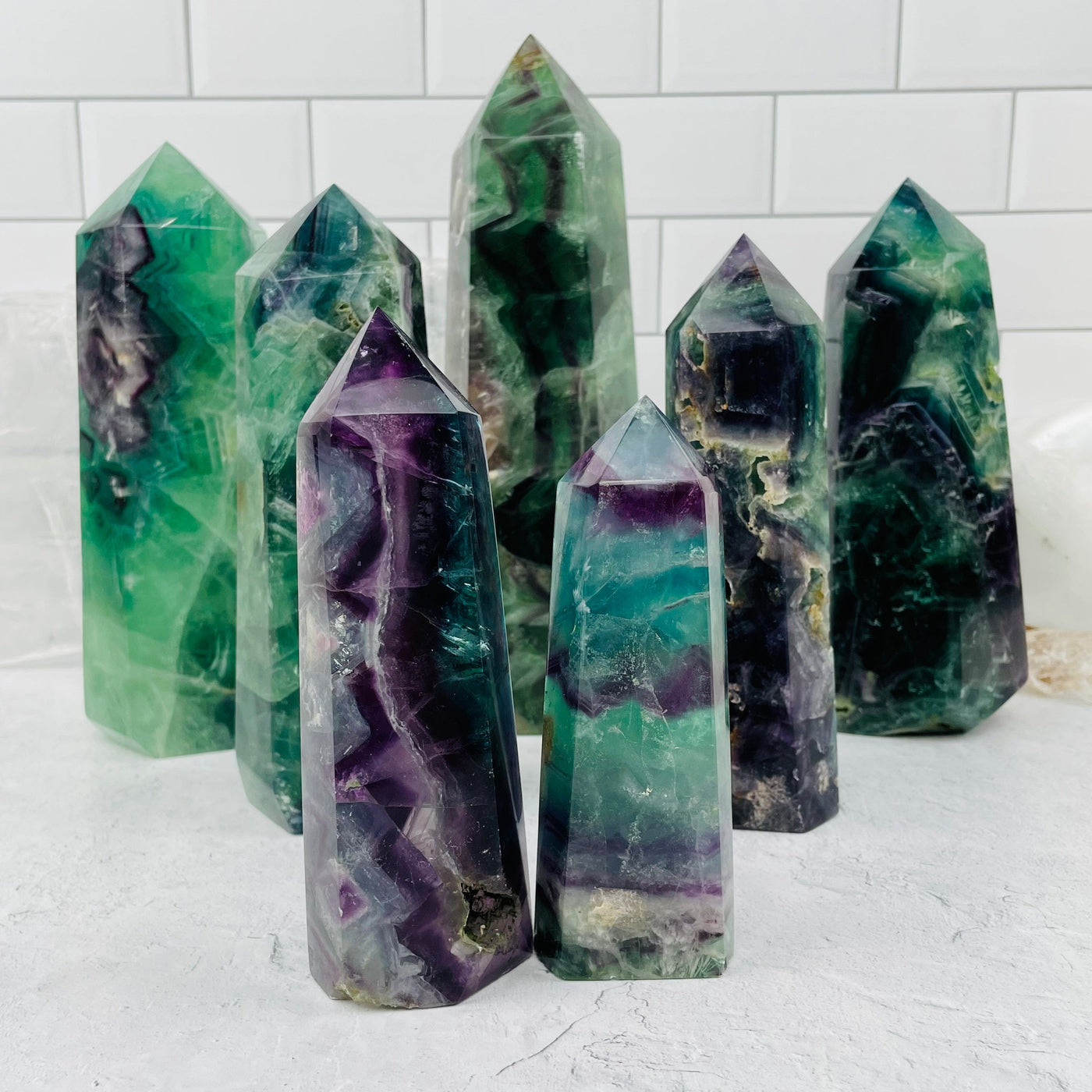 multiple rainbow fluorite polished points displayed to show the differences in the sizes and color shades 
