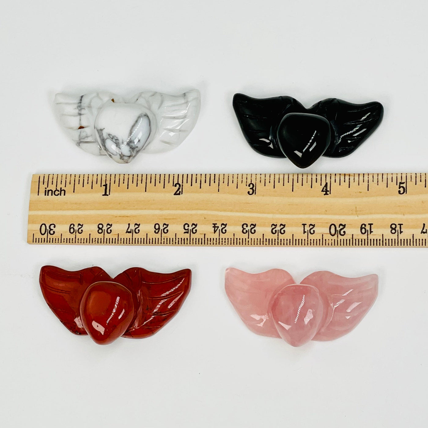 heat with wings carved gemstones next to a ruler for size reference 