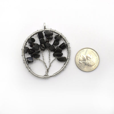 black onyx Tree of Life Pendant next to a quarter for size reference