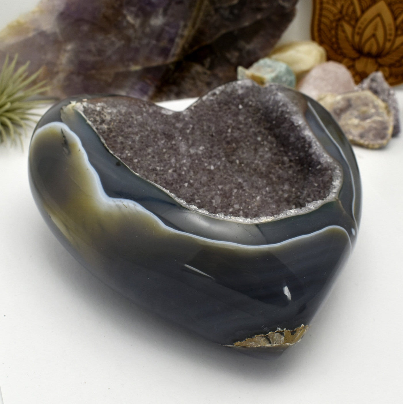 An angled view of Agate Druzy Polished Heart (DOOAK-S24-18) in an alter with a white background.