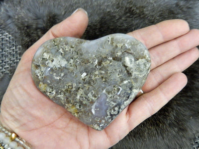 hand holding up druzy heart showing back view