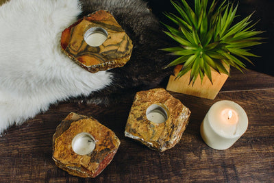 3 tiger eye candle holders on a wood background