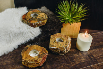 3 tiger eye candle holders on a wood background 