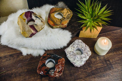 all4 stone options of candle holders on a wood backdrop with fur underneath 2 of the candle holders. 