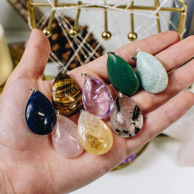 Gemstone Teardrop Pendants of assorted stones in a hand for size reference