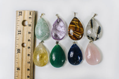 Gemstone Teardrop pendants next to a ruler for size reference