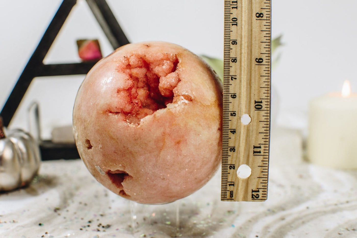 Pink Amethyst Sphere next to a ruler for size reference