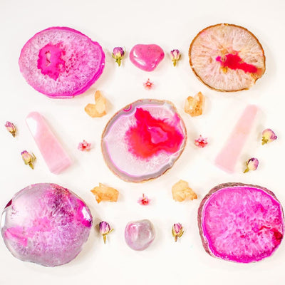 Picture of five of our pink Thick coasters, decorated by some rose quartz towers and citrine points. 