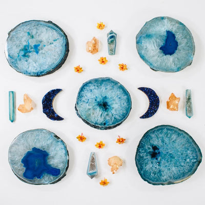 Picture of 5 of our blue thick style coasters, decorated with some moons, citrine points and flowers.