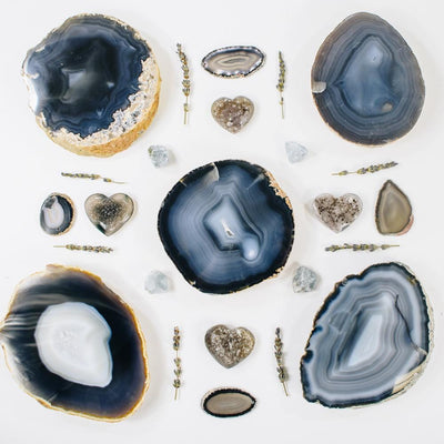 Picture of 5 of our back thick coasters, decorated by some of our agate hearts, celestite stones and flowers.