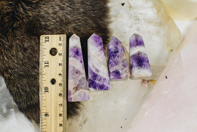 Chevron amethyst towers are being displayed next to each other, and a ruler for size reference.