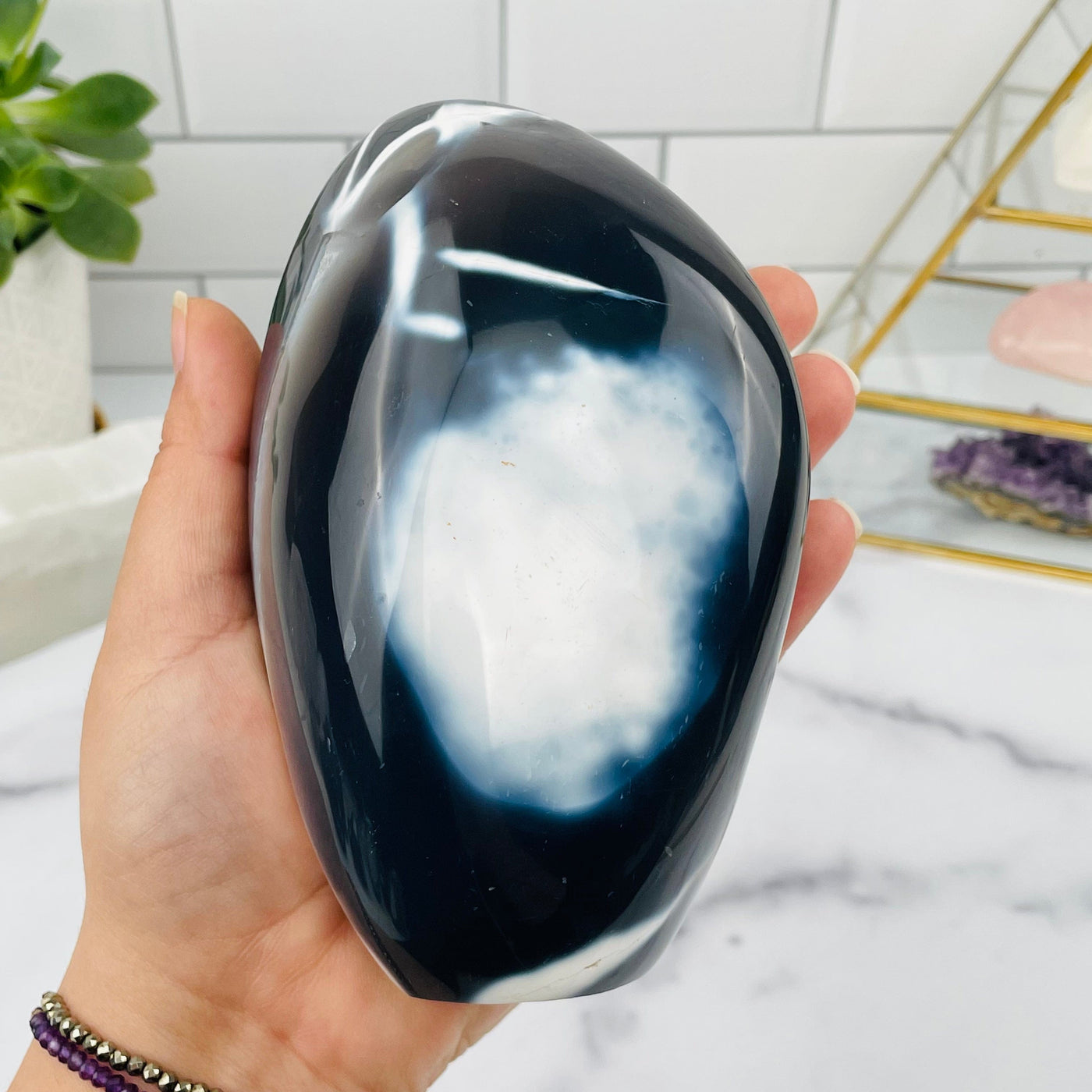 orca agate cut base in hand for size reference 