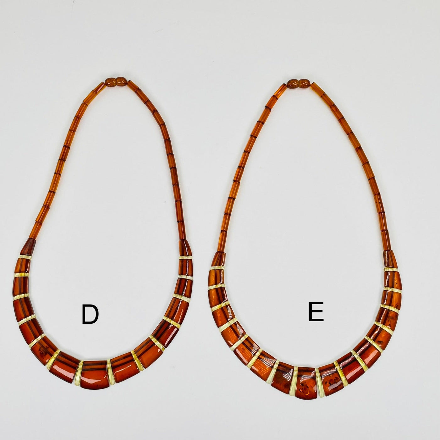 Aerial view of necklace options d and e displayed on a white surface.