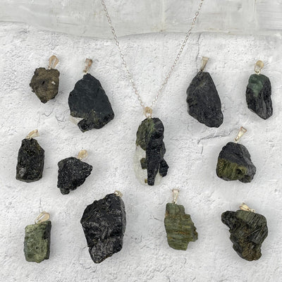 multiple Rough Stone Pendants with Silver Plated Bails displayed to show the differences in the sizes and color shades 