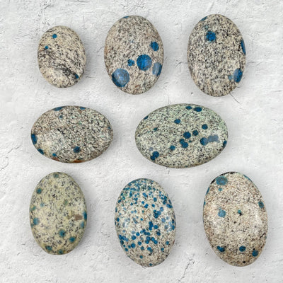 multiple palm stones displayed to show the differences in the sizes and color shades 