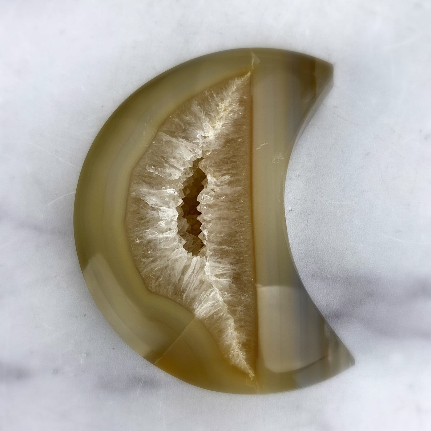 CLose up of Agate Druzy Moon on a light colored background.