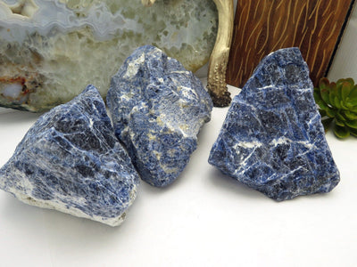 three sodalite rough stones on display