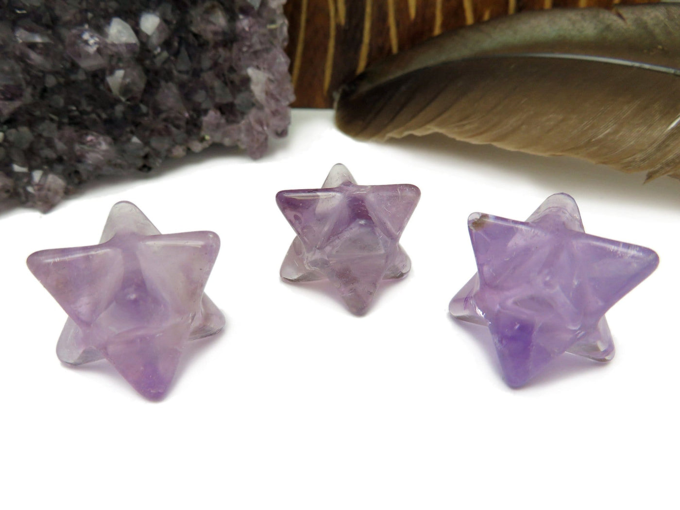 3 amethyst merkaba on a white background.