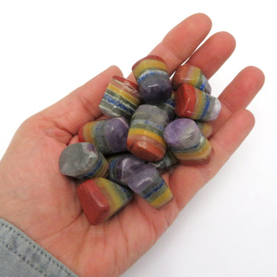 many seven chakra tumbled stones in hand for size reference