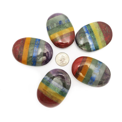 many large seven chakra palm stones with quarter for size reference