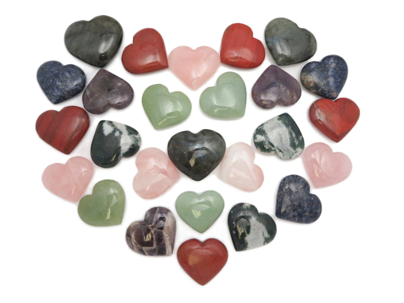 various stone hearts placed in a heart shape on white background
