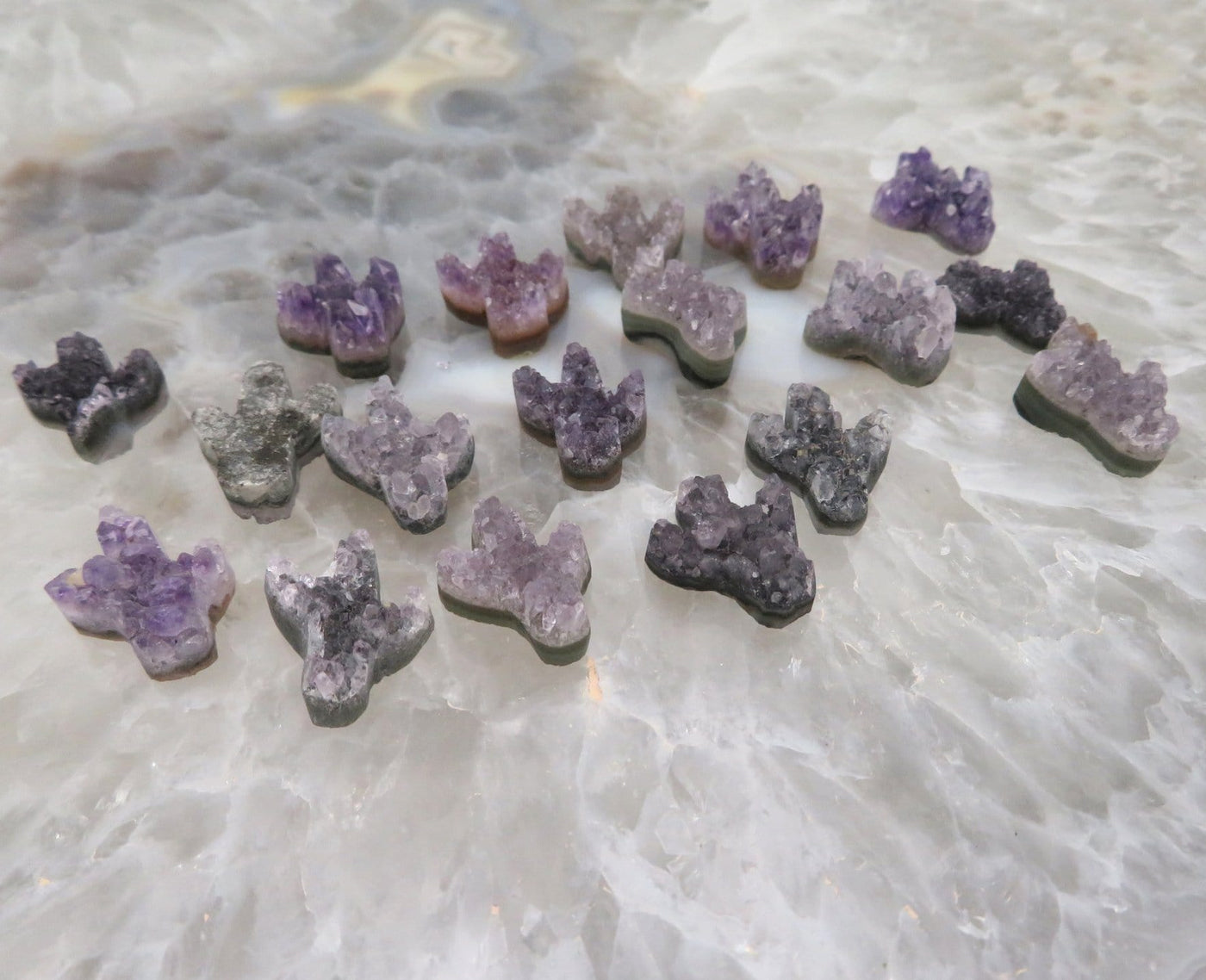 Multiple amethyst cactus being are being displayed on a crystal quartz platter.