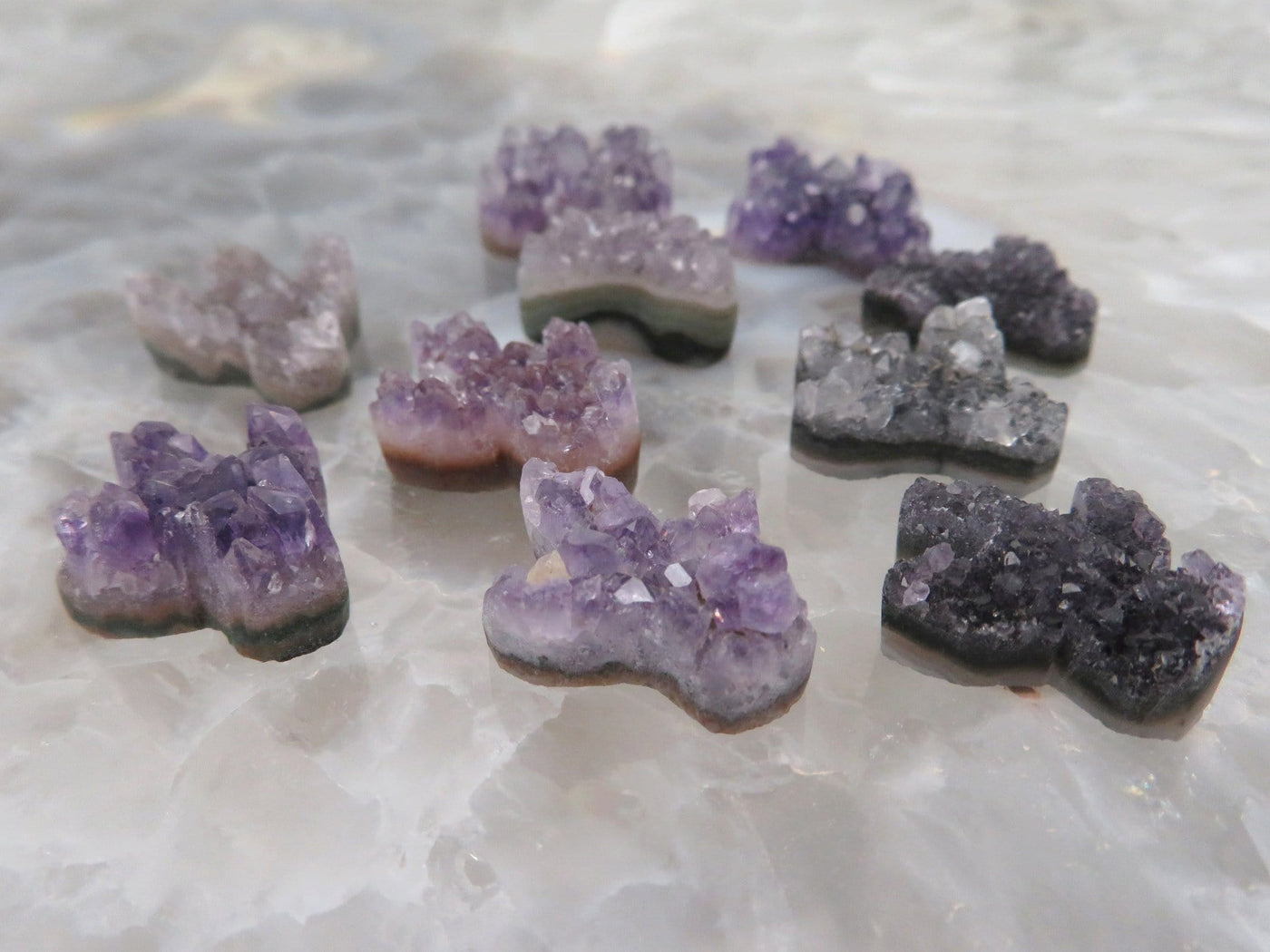 Multiple amethyst cactus being are being displayed on a crystal quartz platter.
