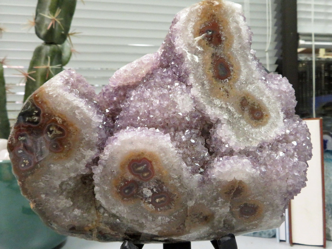 up close shot of amethyst formation with stalactites on metal stand