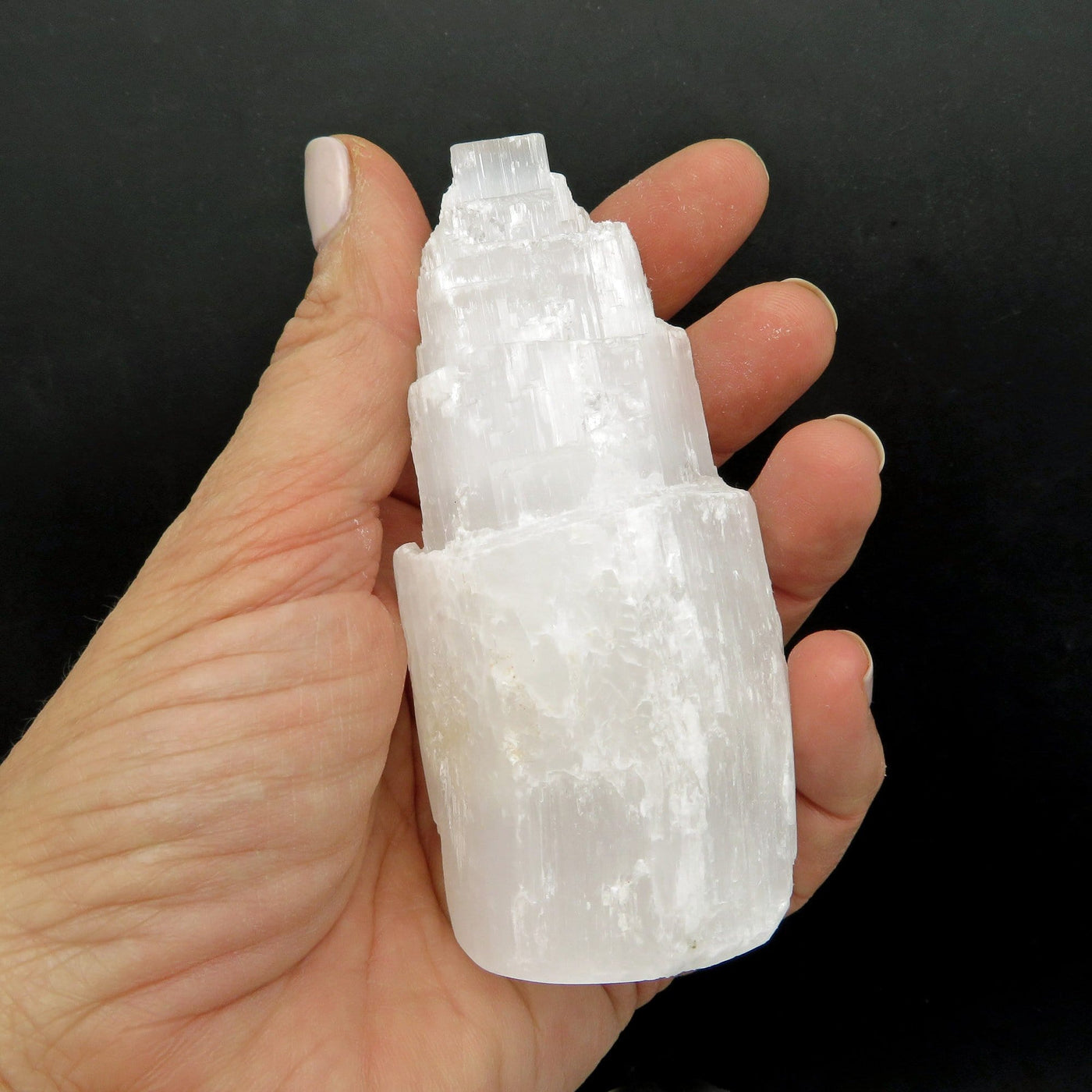 4 inch selenite tower in a woman's hand