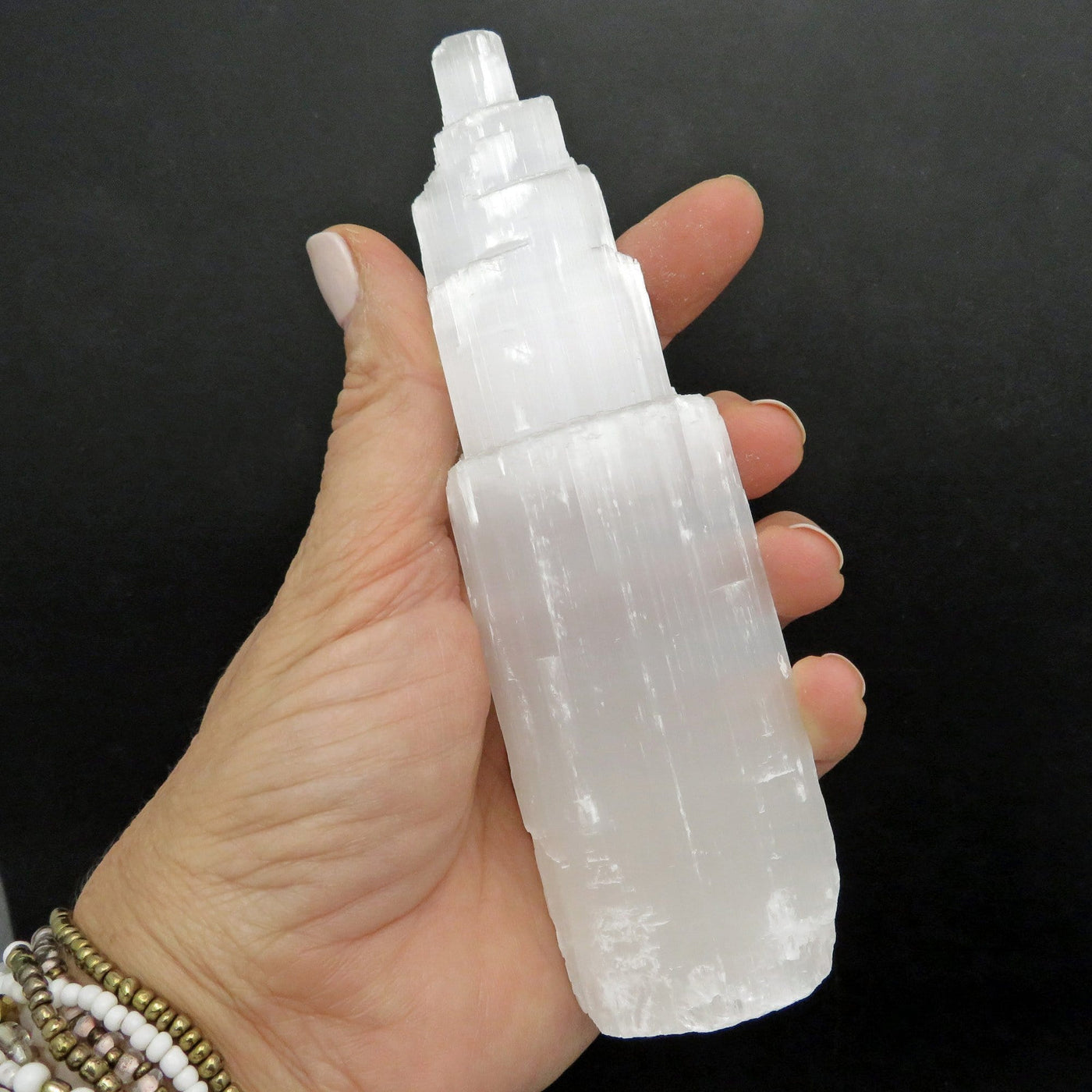6 inch selenite tower in a woman's hand