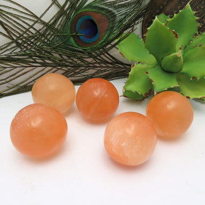 orange selenite spheres displayed to show color variation